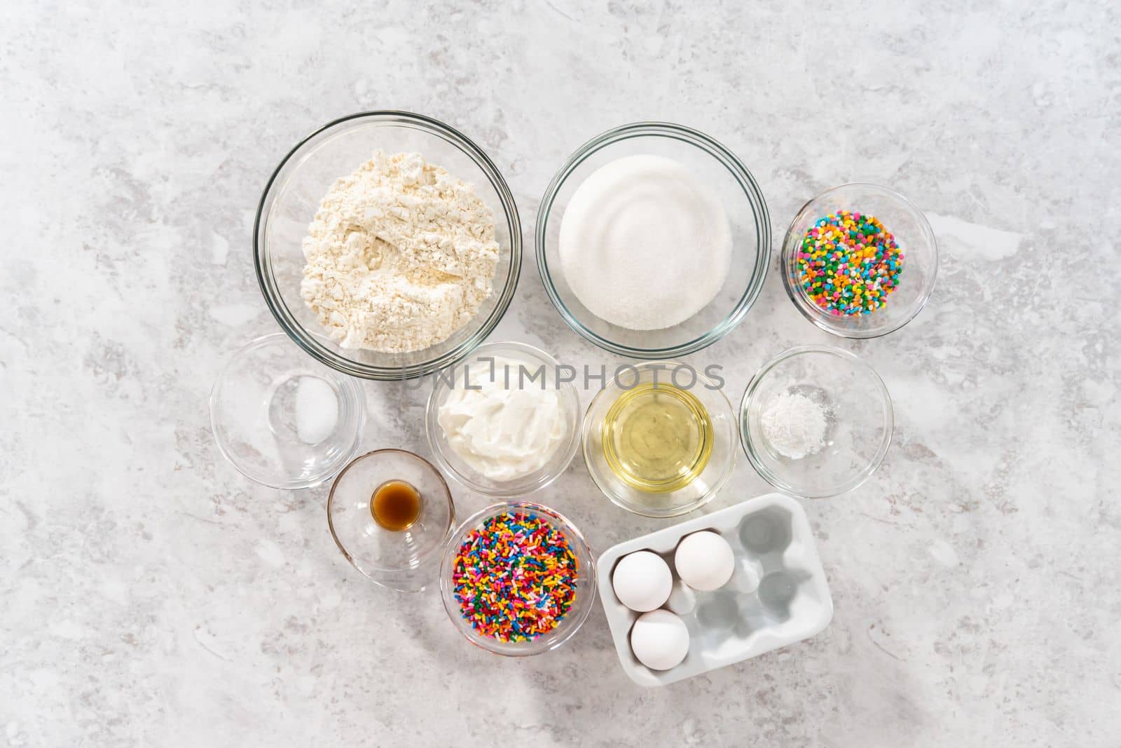 Flat lay. Ingredients in glass mixing bowls to bake funfettti bundt cake.