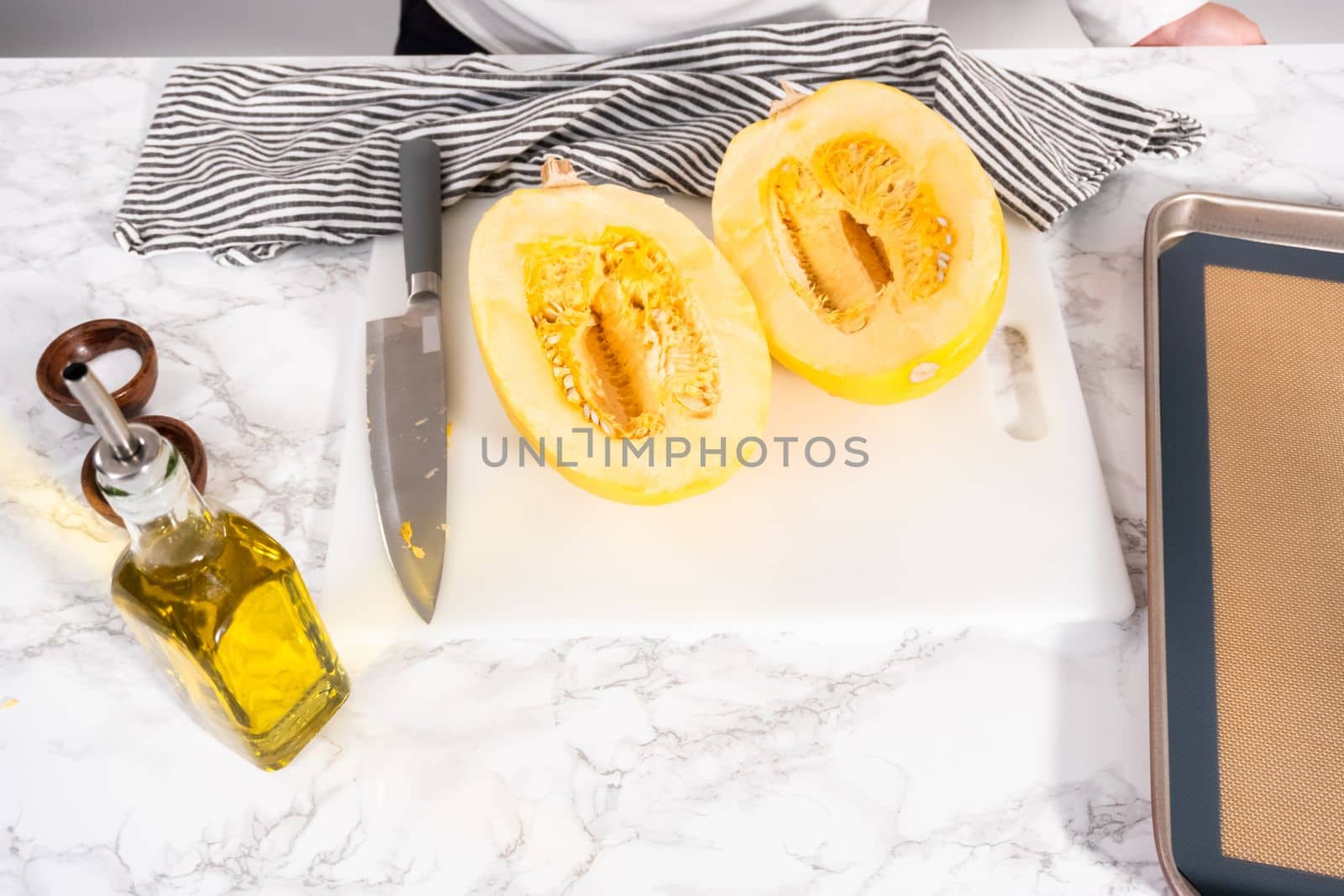 Preparing organic spaghetti squash with olive oil, salt, and pepper.