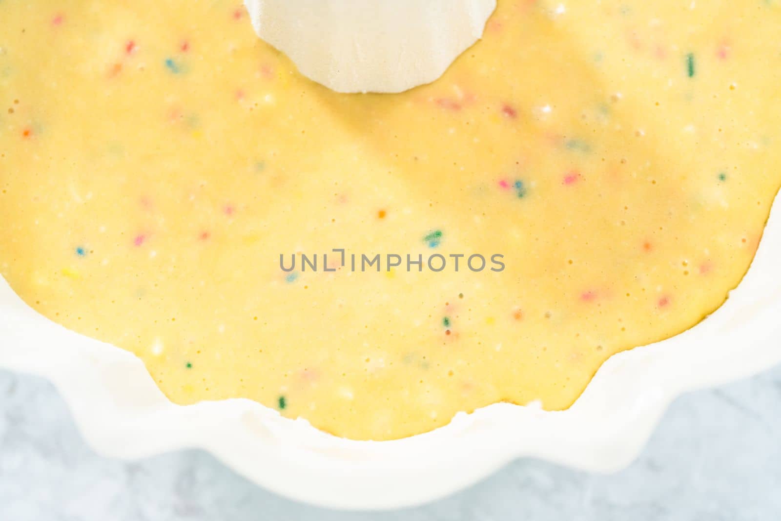 Close up view. Cake batter in a bundt cake pan to bake funfettti bundt cake.