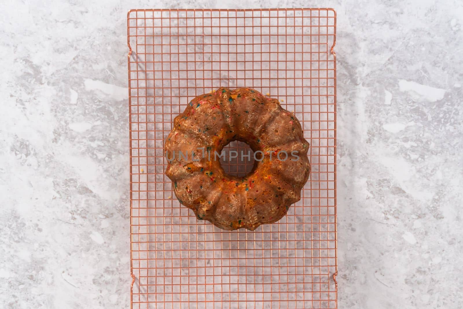 Flat lay. Cooling freshly baked funfettti bundt cake on a wire rack.