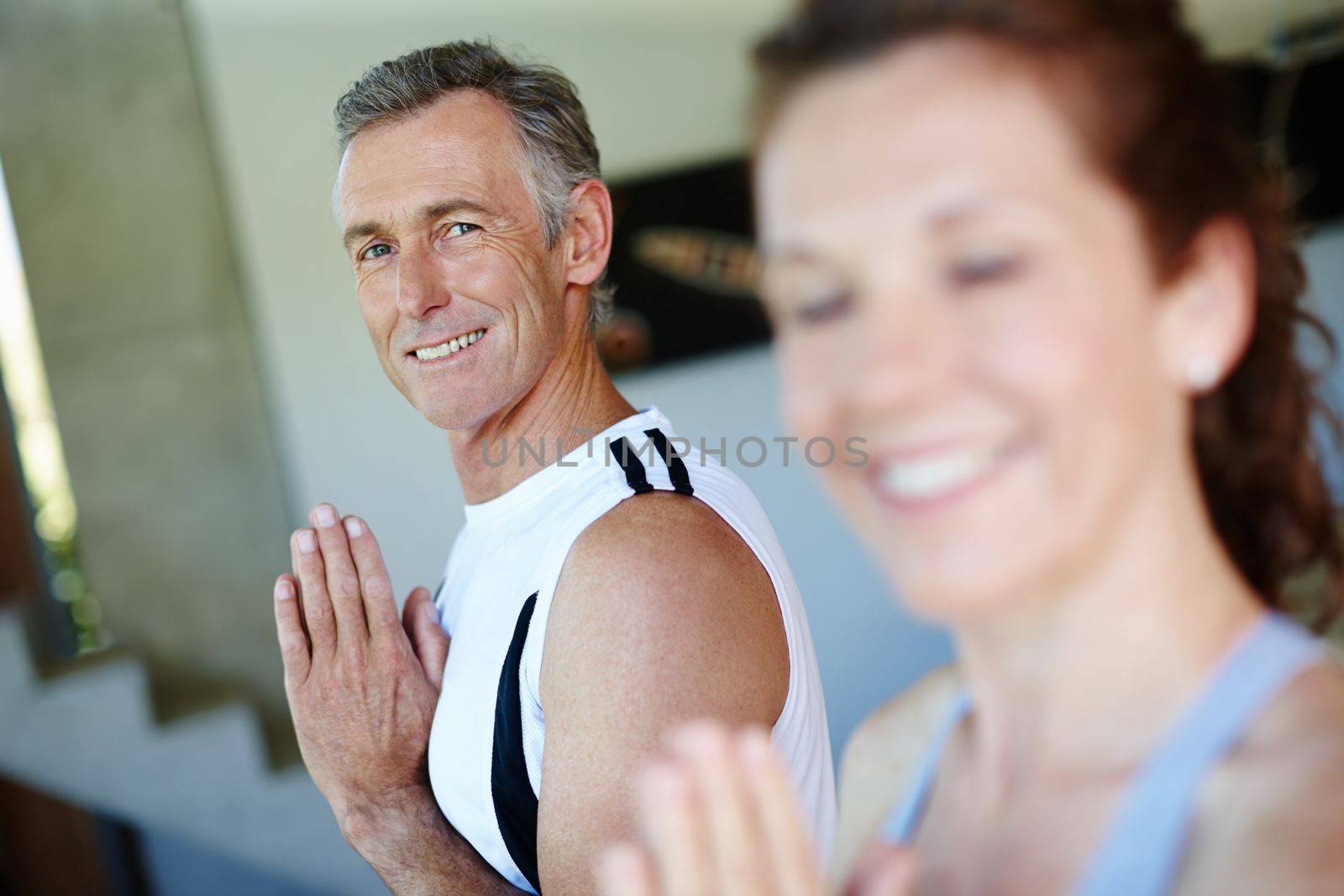 Yoga keeps him balanced. A mature man enjoying a yoga class with a smile of positivity