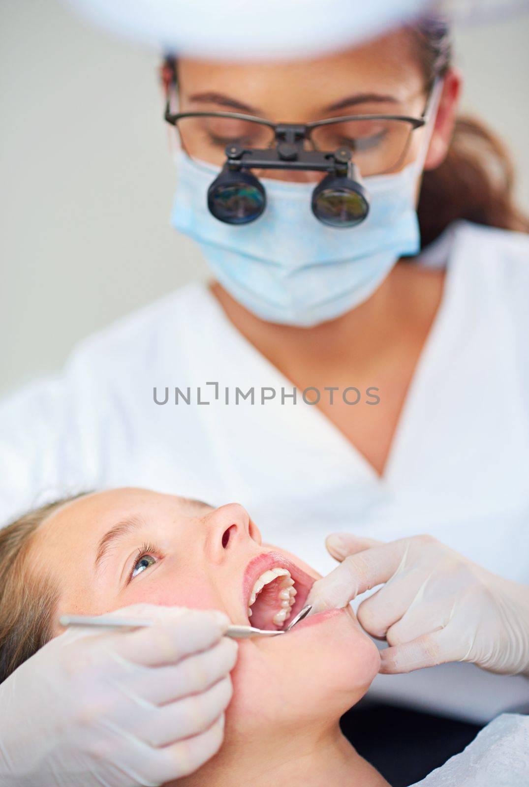 Shes in very capable hands. a female dentist and child in a dentist office