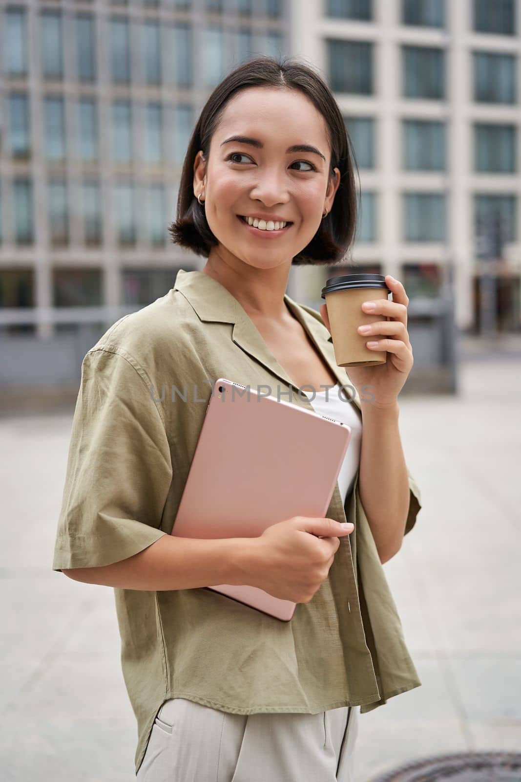 Portrait of asian girl with tablet, drinks coffee on street, walking in city centre.