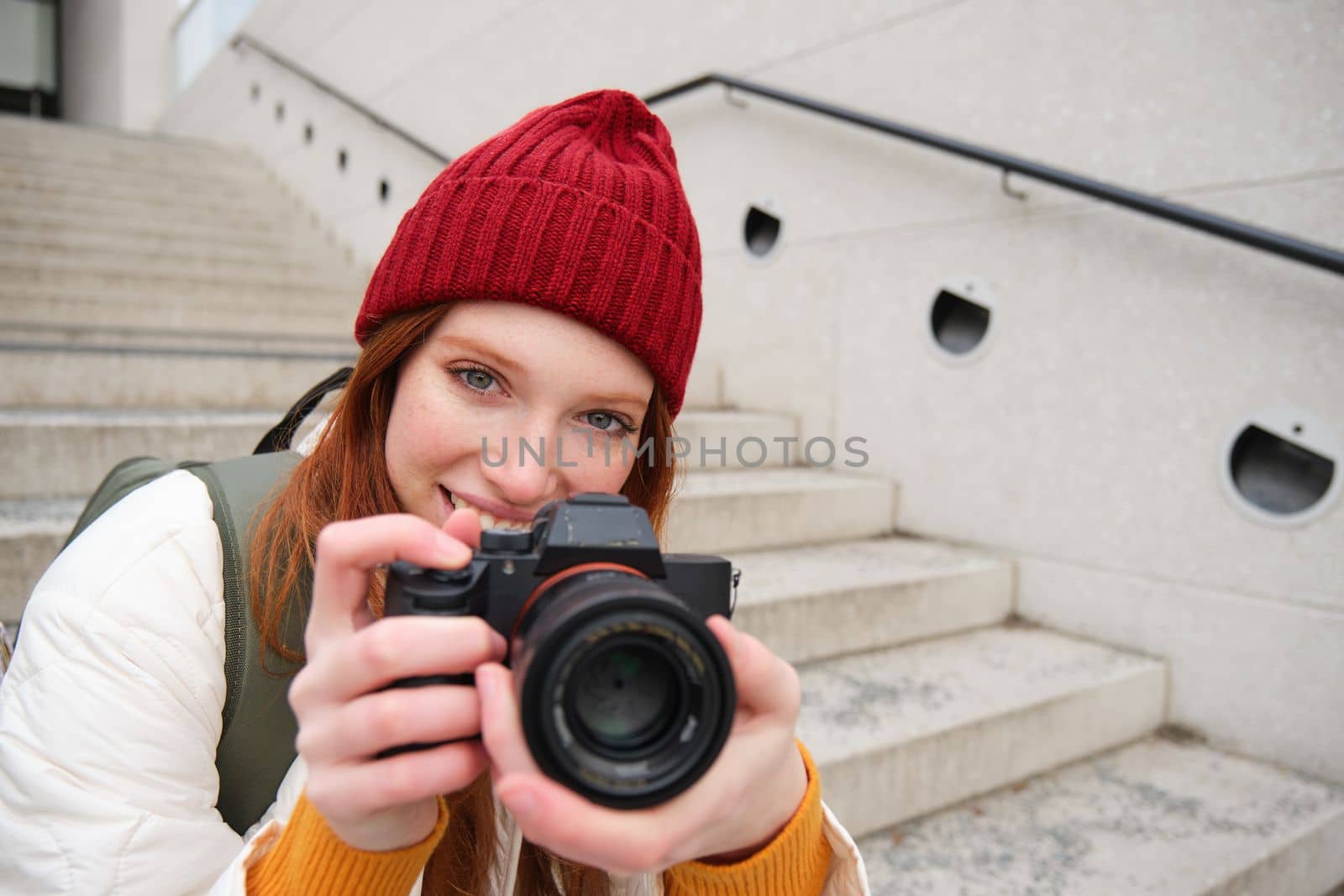Portrait of female photographer walking around city with professional camera, taking pictures capturing urban shots, photographing outdoors.