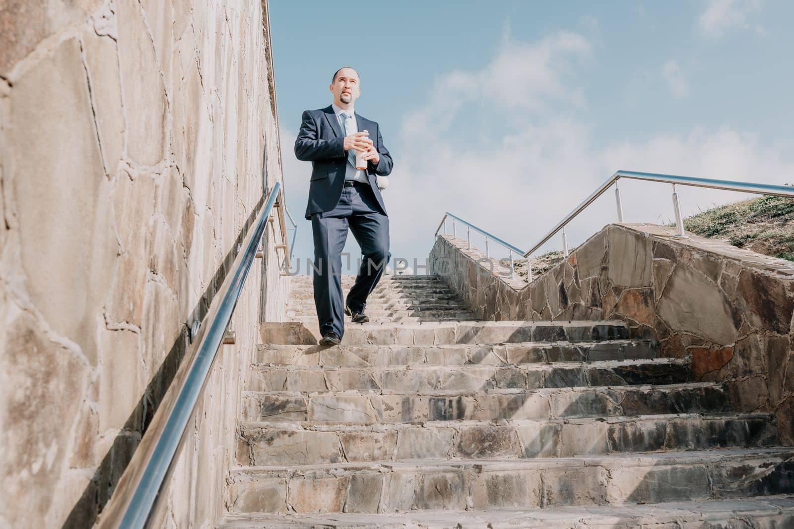 Business executive with briefcase going down the stairs.