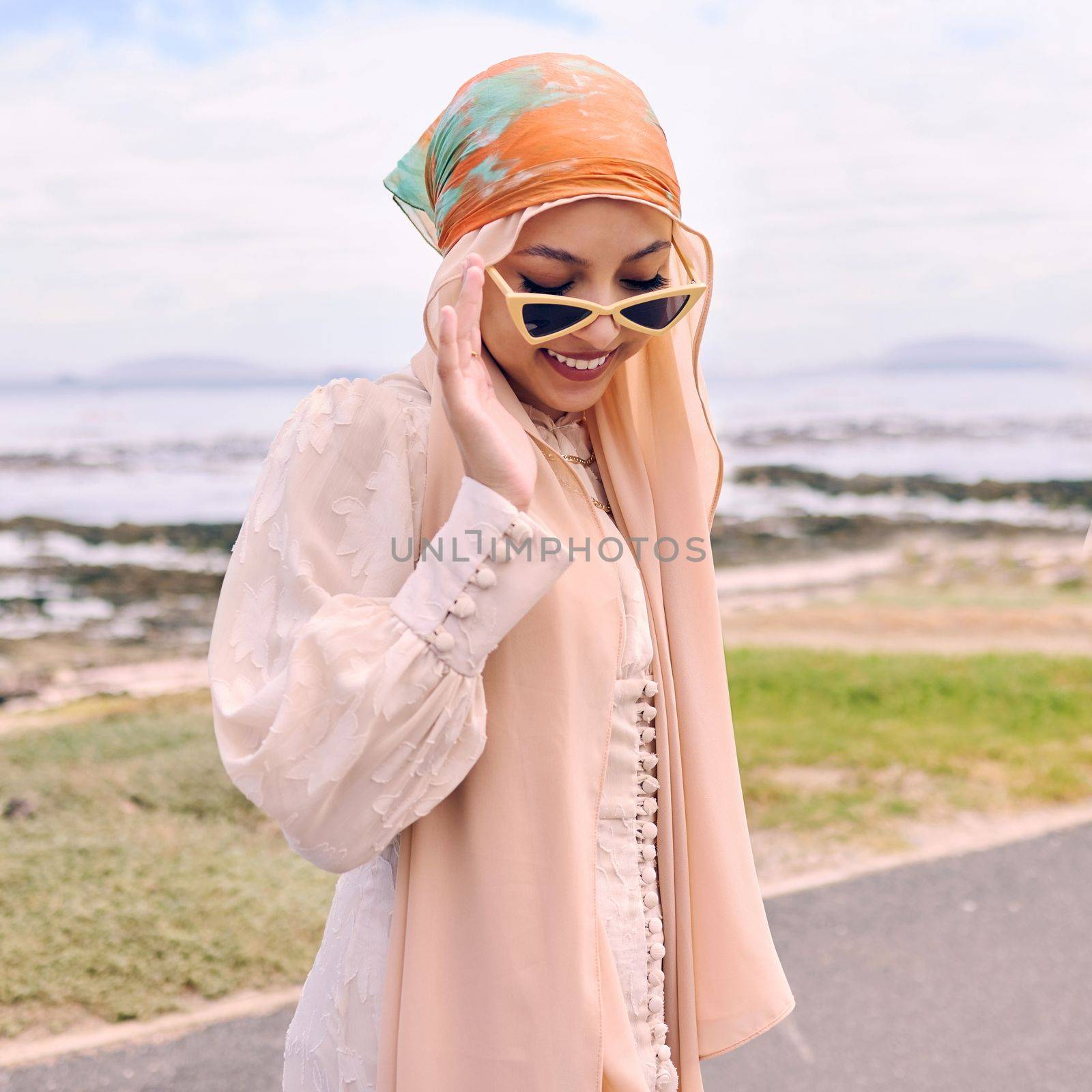 Beautiful young arab woman posing outdoors in a headscarf. Attractive female muslim wearing a hijab posing outside. Shes all about style and fashion. Mixed race woman looking confident and trendy by YuriArcurs