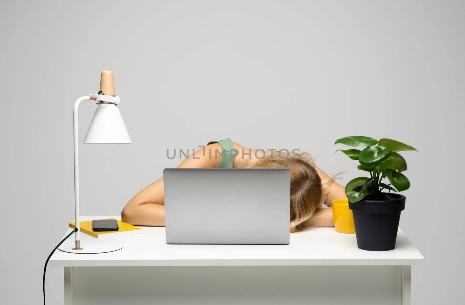Young frustrated exhausted woman laid her head down on the table sit work at white desk with contemporary pc laptop. Achievement business career concept. by vovsht