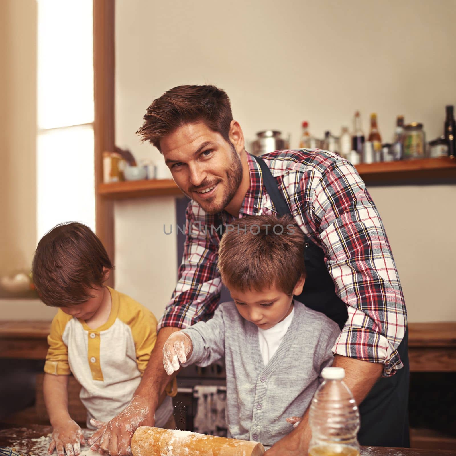 They love baking. two young brothers baking with their father in the kitchen. by YuriArcurs