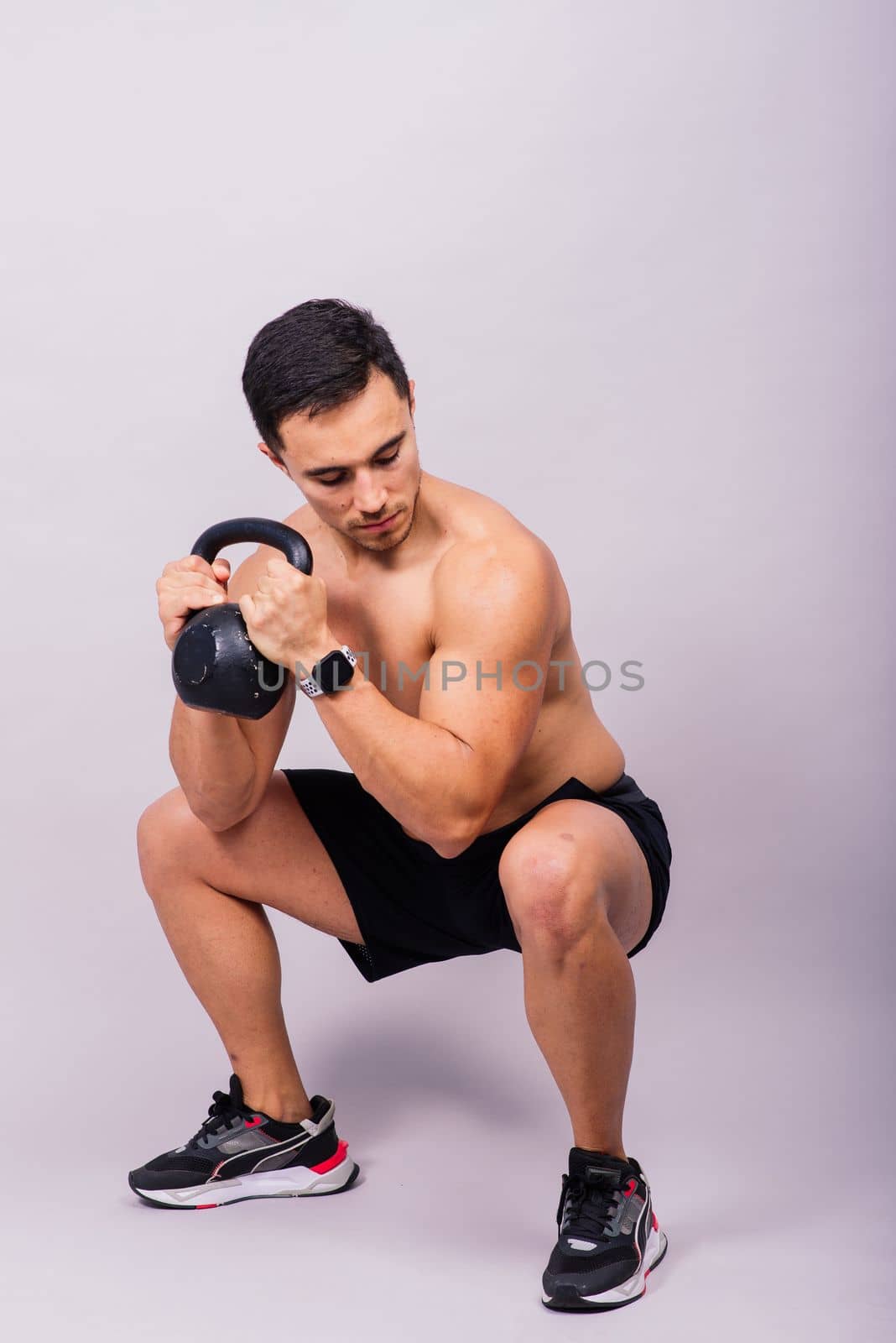 Sporty man working out with a kettlebell. Photo of man on dark background. Strength and motivation by Zelenin