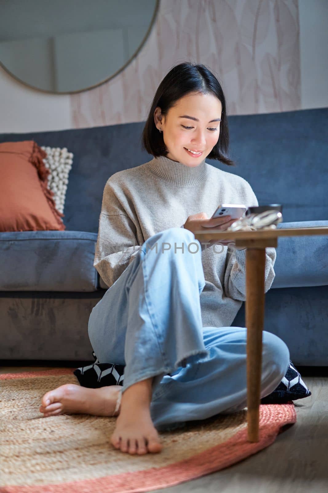 Technology and people. Young stylish asian woman sits at home with her smartphone, texting message, using application on mobile phone.