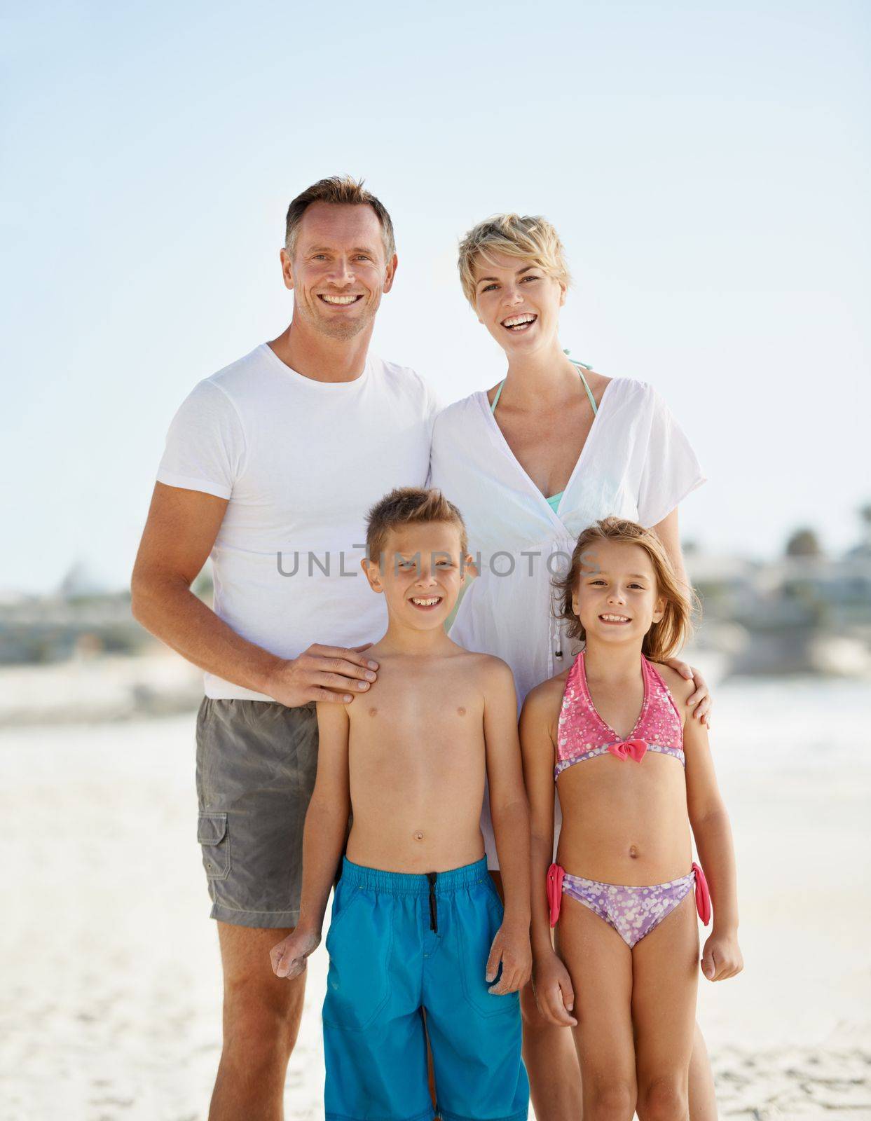 Well always remember this vacation. A happy young family standing on the beach while on vacation