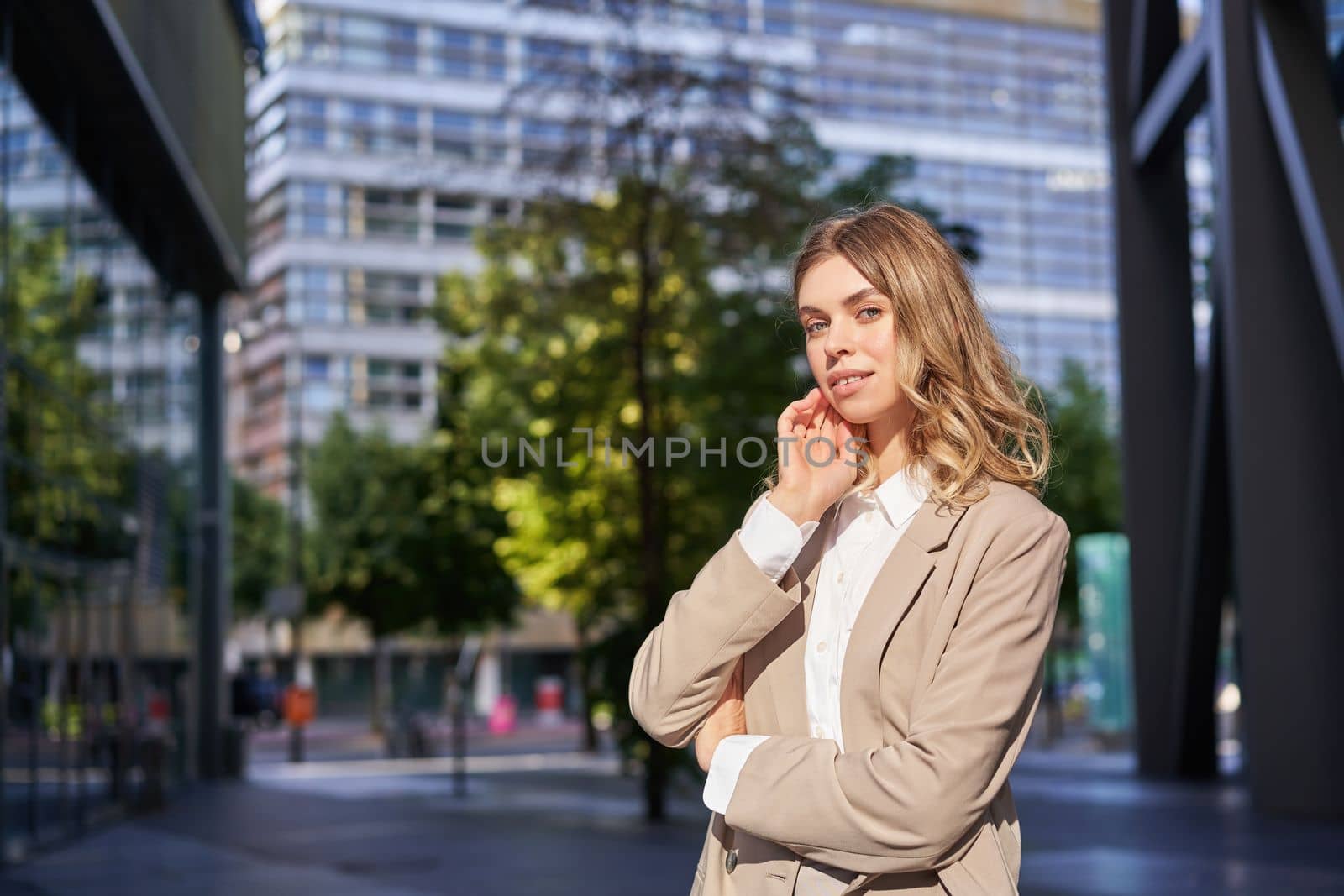 Successful working woman, office manager in suit, cross arms on chest, looking with confidence by Benzoix