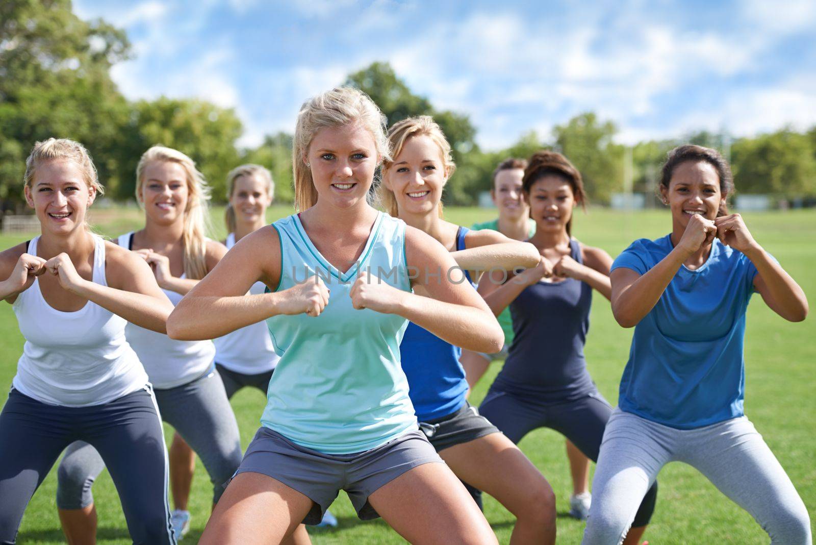 Sunshine and exercise. a group of young women exercising outdoors