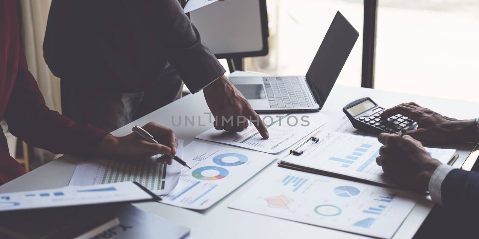 Close up of Diverse colleagues gather brainstorm discuss financial statistics at office meeting. finance, teamwork, Big data Graphs Charts concept.