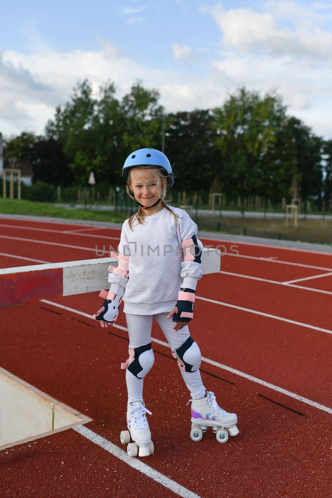 Girl in vintage white roller skates and a helmet at the stadium