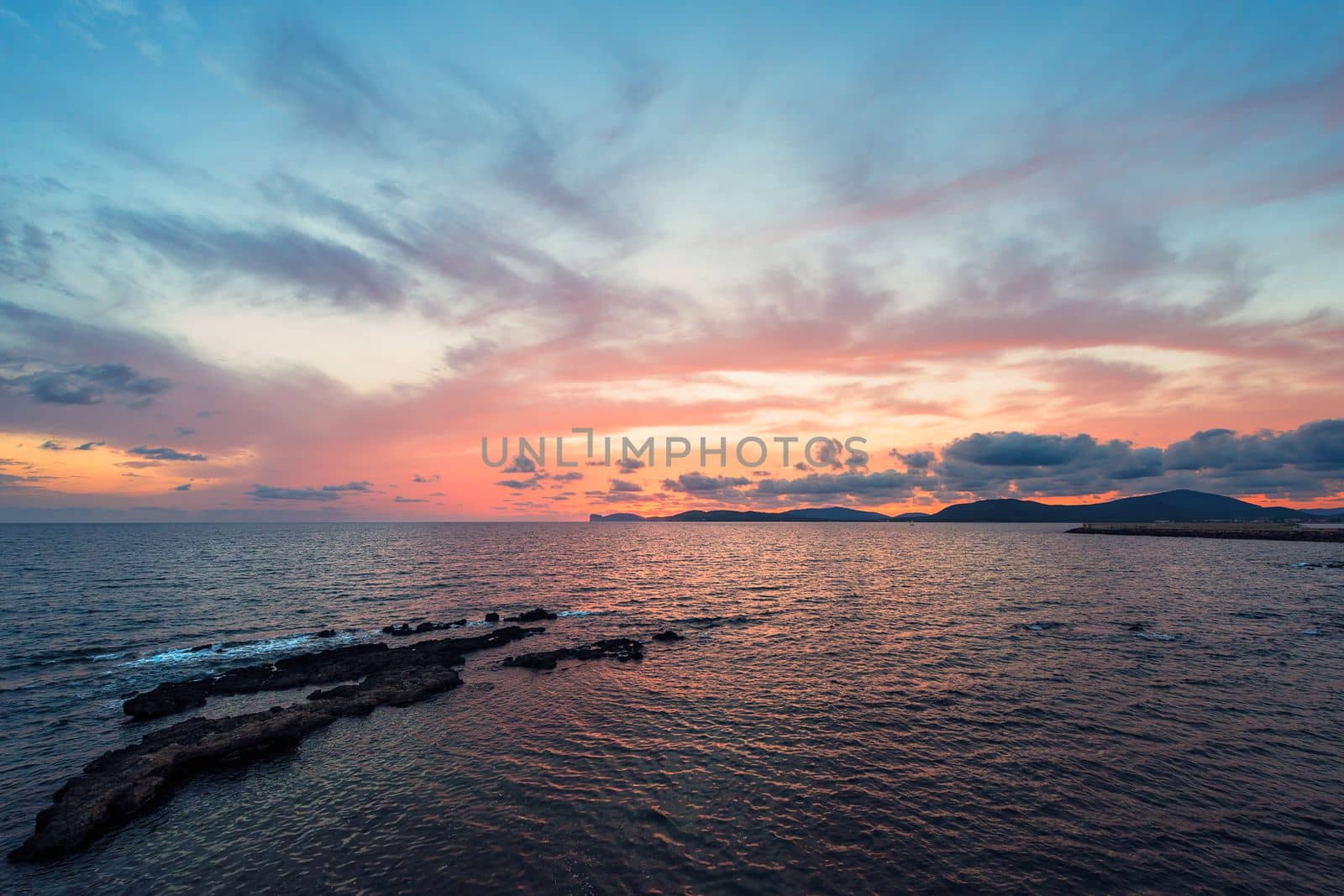 amazing colorful sunset in the Gulf of Alghero, Sardinia, Italy