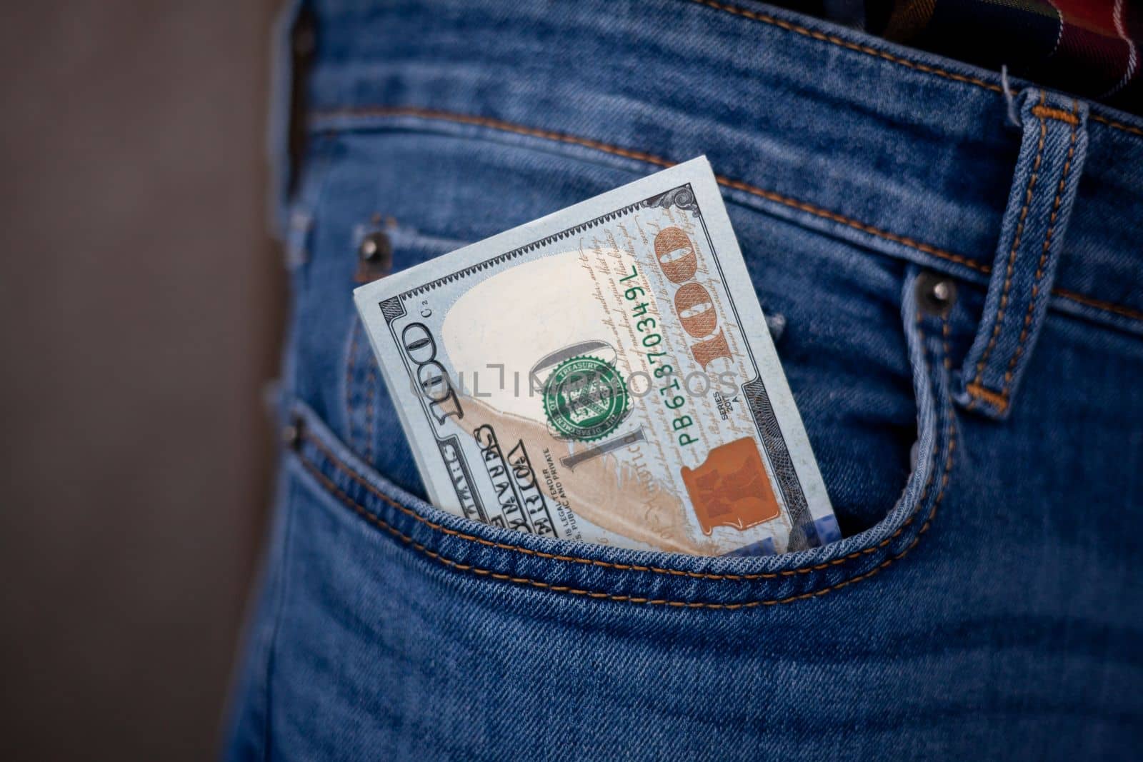 Many dollar 100 banknotes in a jeans pocket. One hundred dollar bills in a pocket of favorite trousers.
