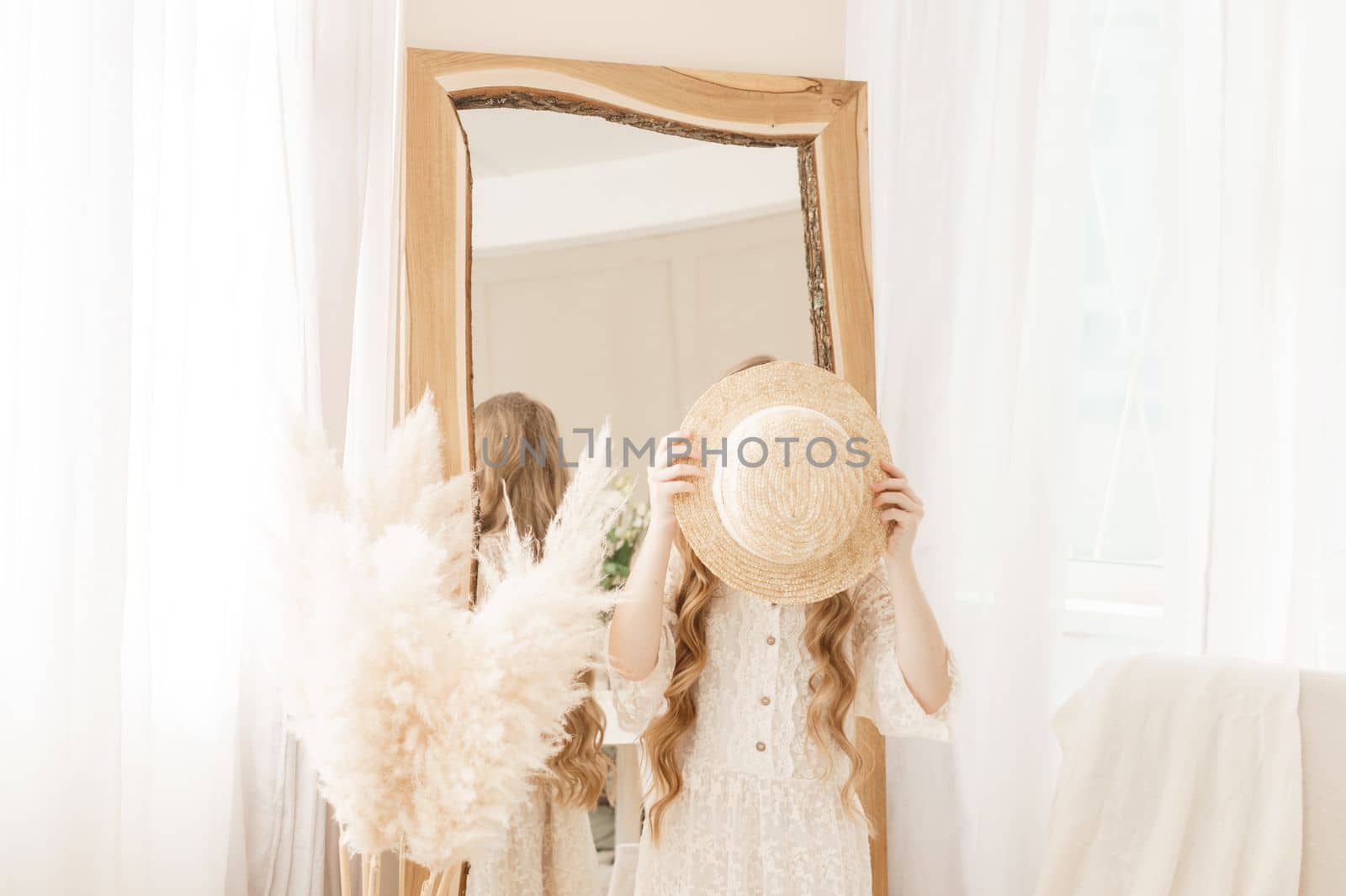 A beautiful teenage girl with long hair measures a straw hat in front of a mirror. Self-admiration of a blonde. by Annu1tochka