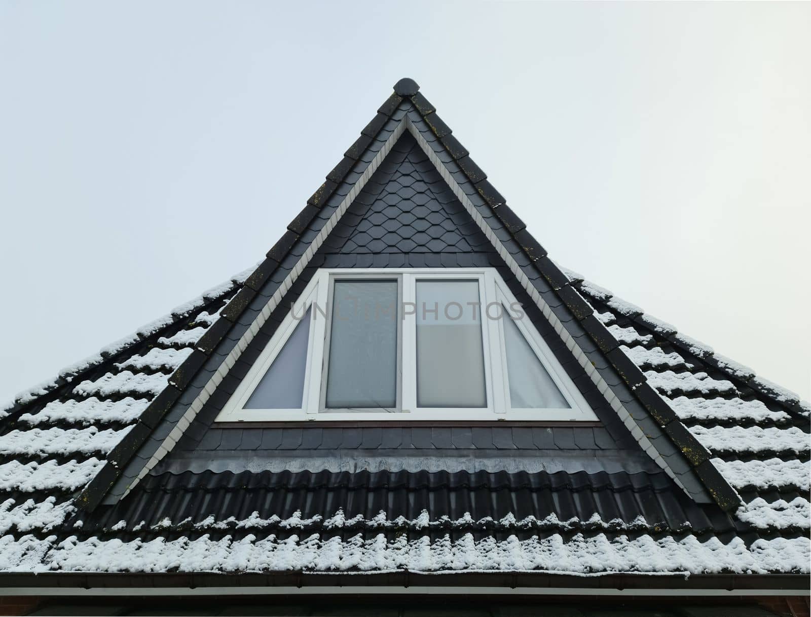 Open roof window in velux style with black roof tiles covered in white snow by MP_foto71