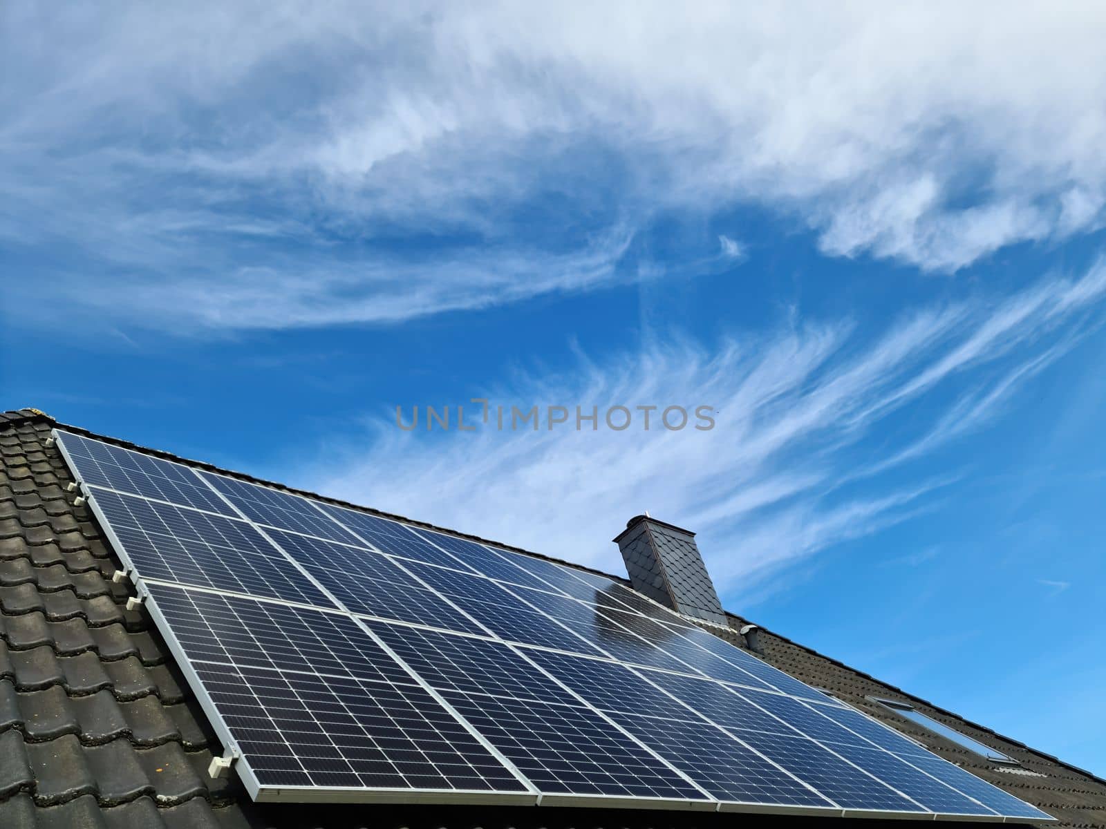 Solar panels producing clean energy on a roof of a residential house in Germany by MP_foto71