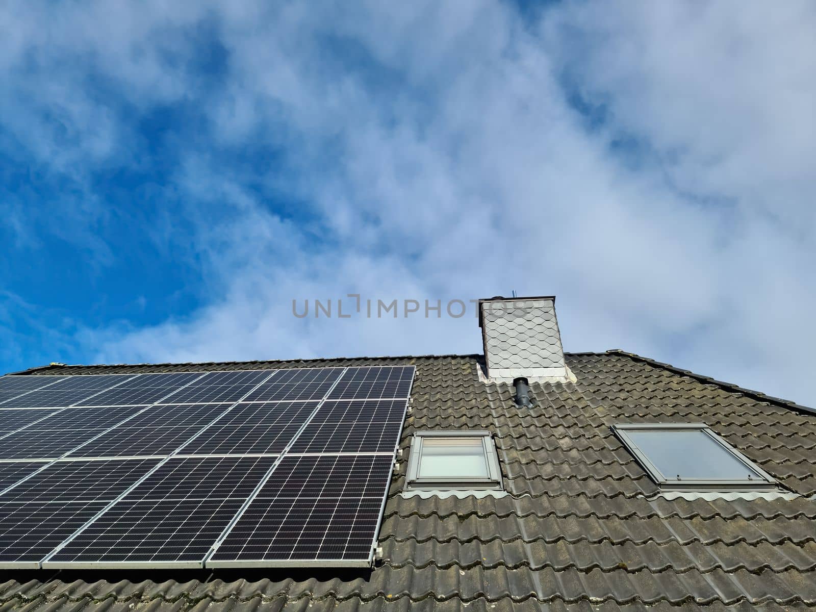 Solar panels producing clean energy on a roof of a residential house in Germany by MP_foto71