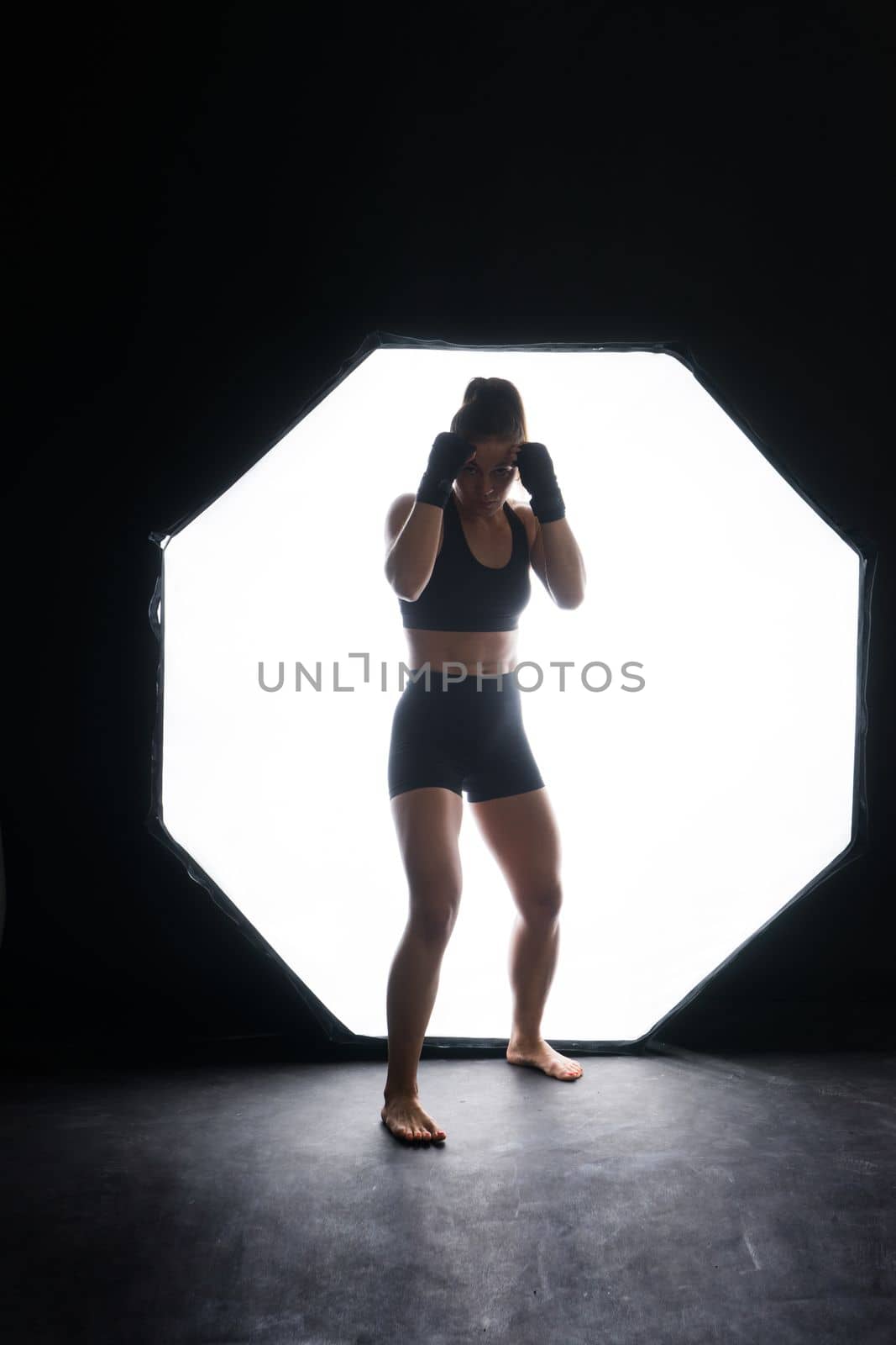 Young woman athletic female MMA fighter is training. Concept of sport, action, healthy lifestyle.