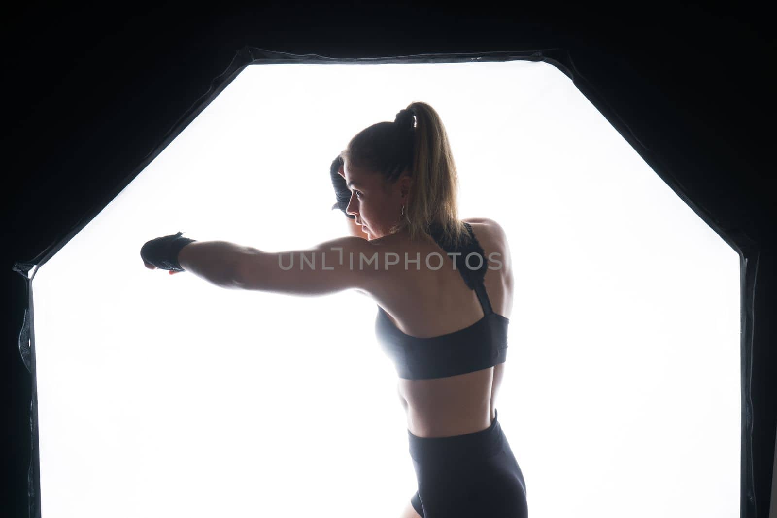 Young woman athletic female MMA fighter is training. Concept of sport, action, healthy lifestyle.