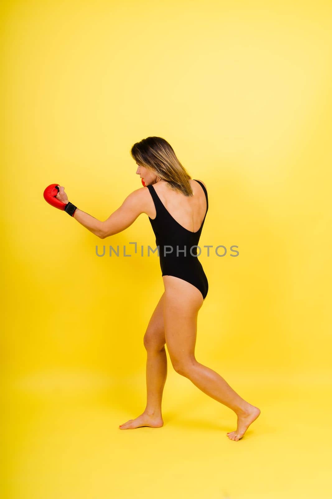 Young woman athletic female MMA fighter is training. Concept of sport, action, healthy lifestyle.