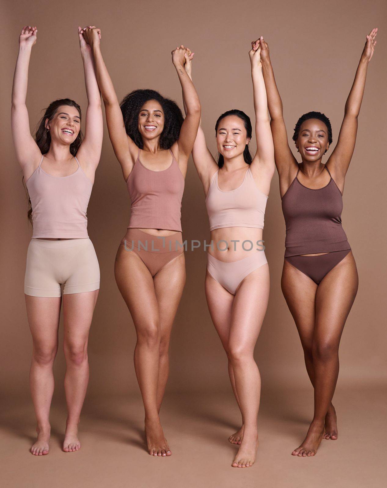 Diversity, woman and celebrate body positive in underwear for beauty motivation, happiness and confidence in studio. Interracial group of people, support and model smile celebration for solidarity.