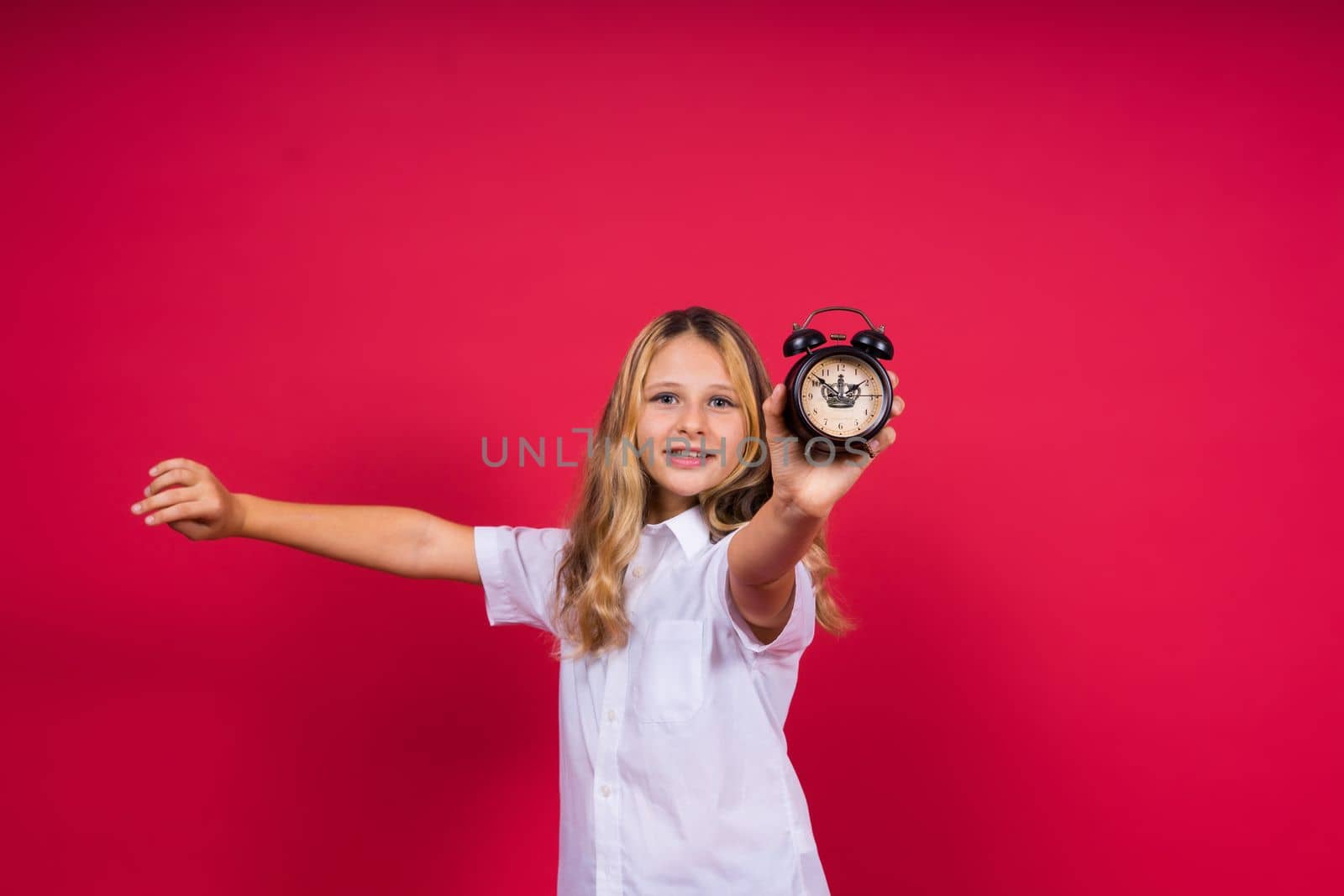 Young Girl holding antique clock over red background