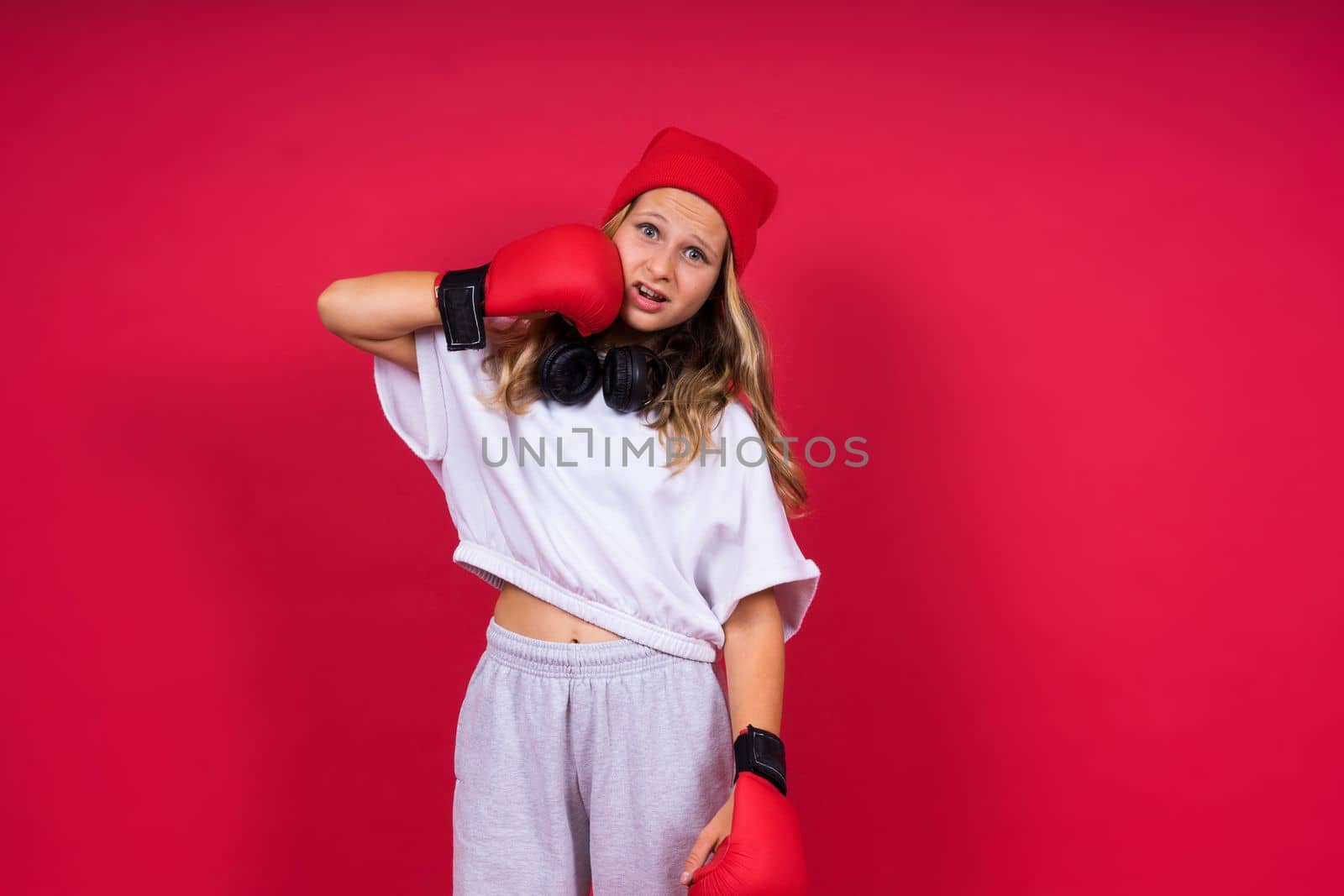 Little girl wearing red boxing gloves, studio shot, sport concept by Zelenin