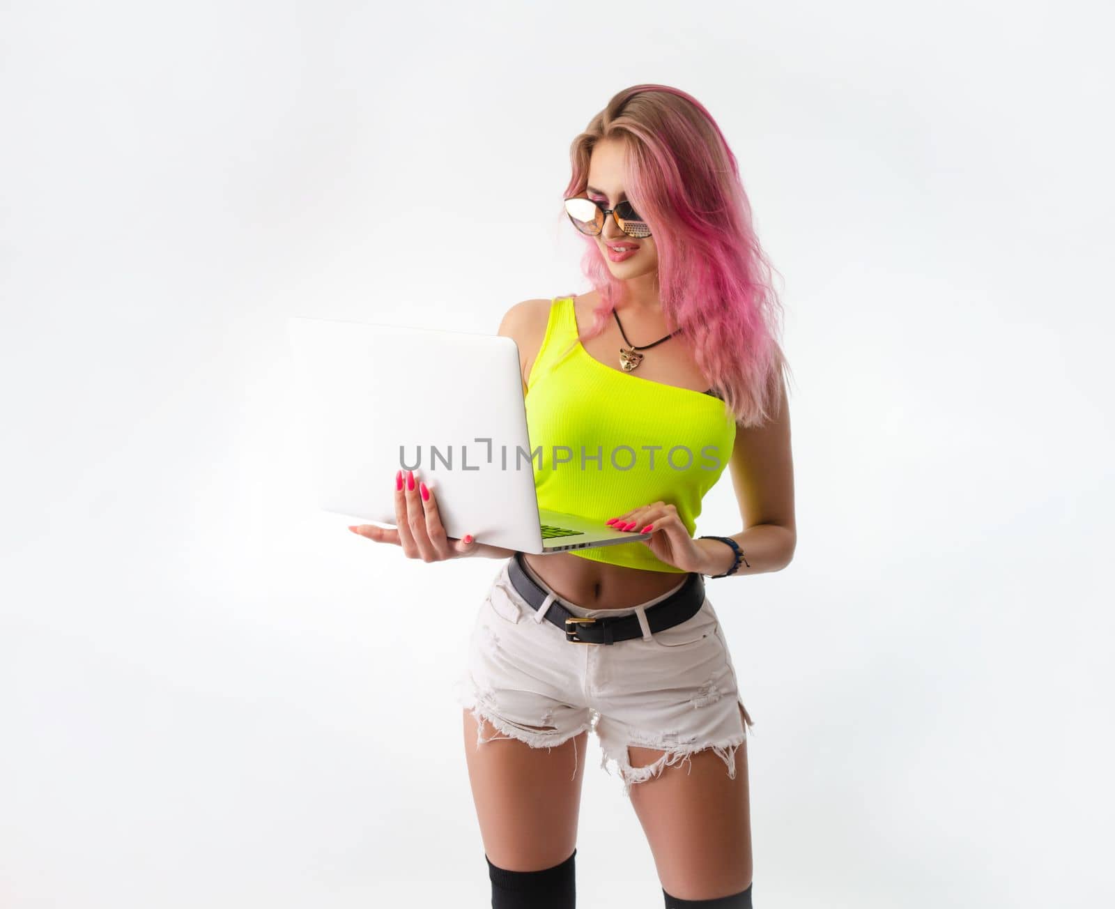 sexy girl in bright summer clothes with a laptop on a white background copy paste