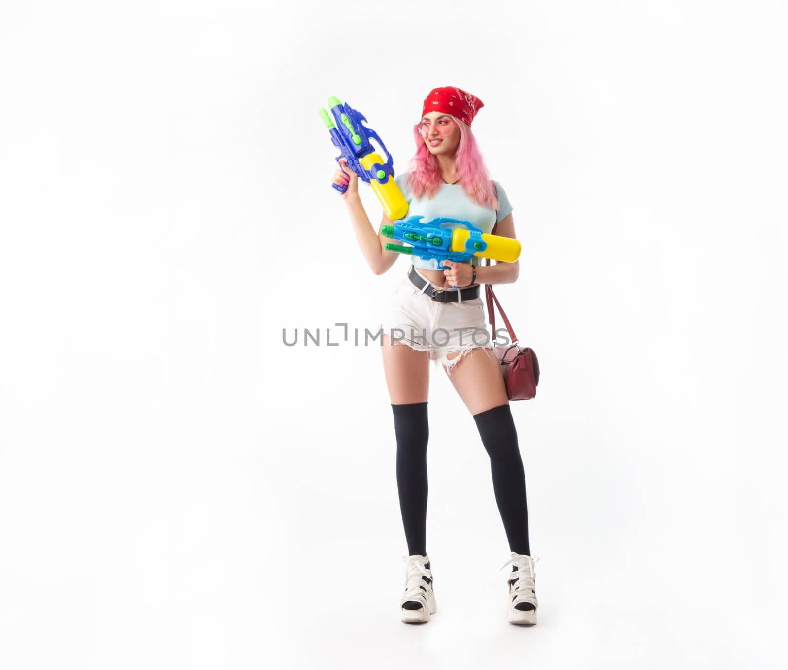 sexy girl with a water gun in summer clothes isolated on a white background copy paste