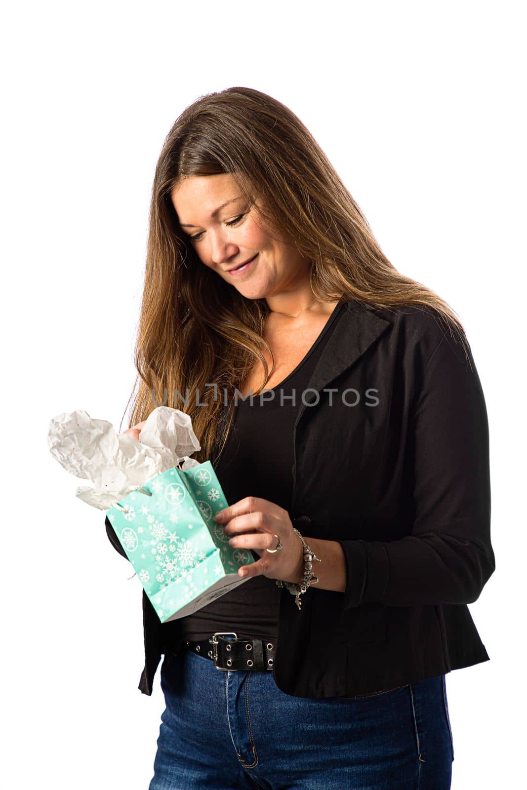 Isolated portrait of a forty year old woman in a sport coat, opening a gift bag
