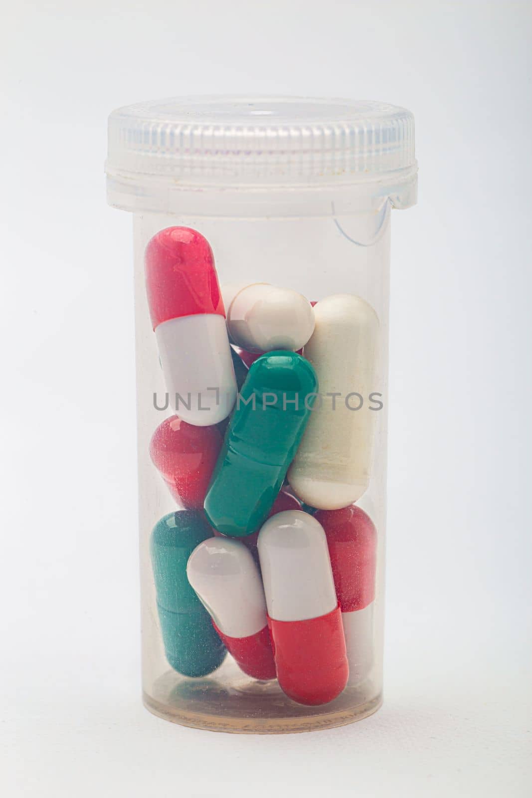 Bottle containing multi-colored pill inside a transparent bottle