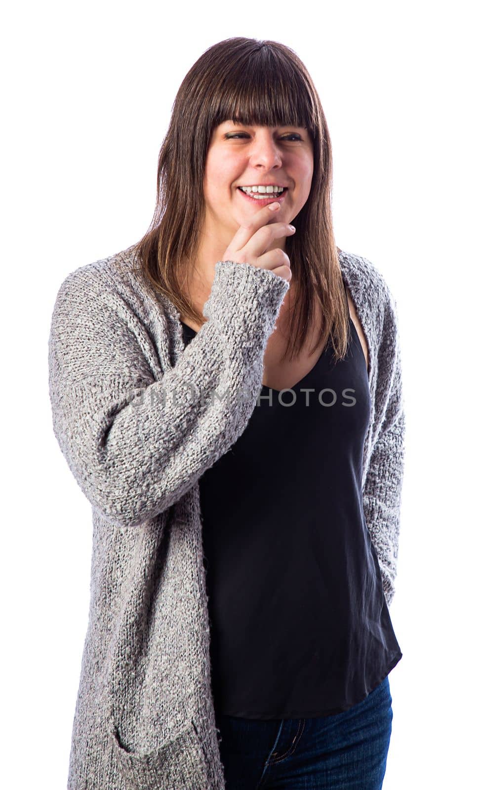 Isolated portrait of a fifty year old woman, with brown hair and bangs, holding her chin having a funny though