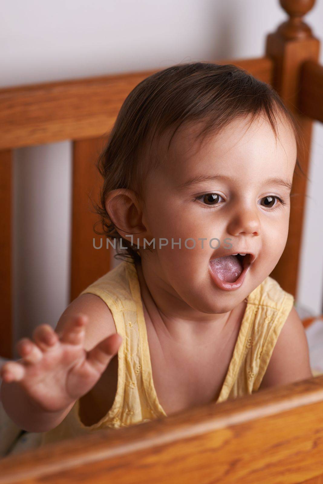 Theres so much world to explore. A cute little girl standing up in her crib