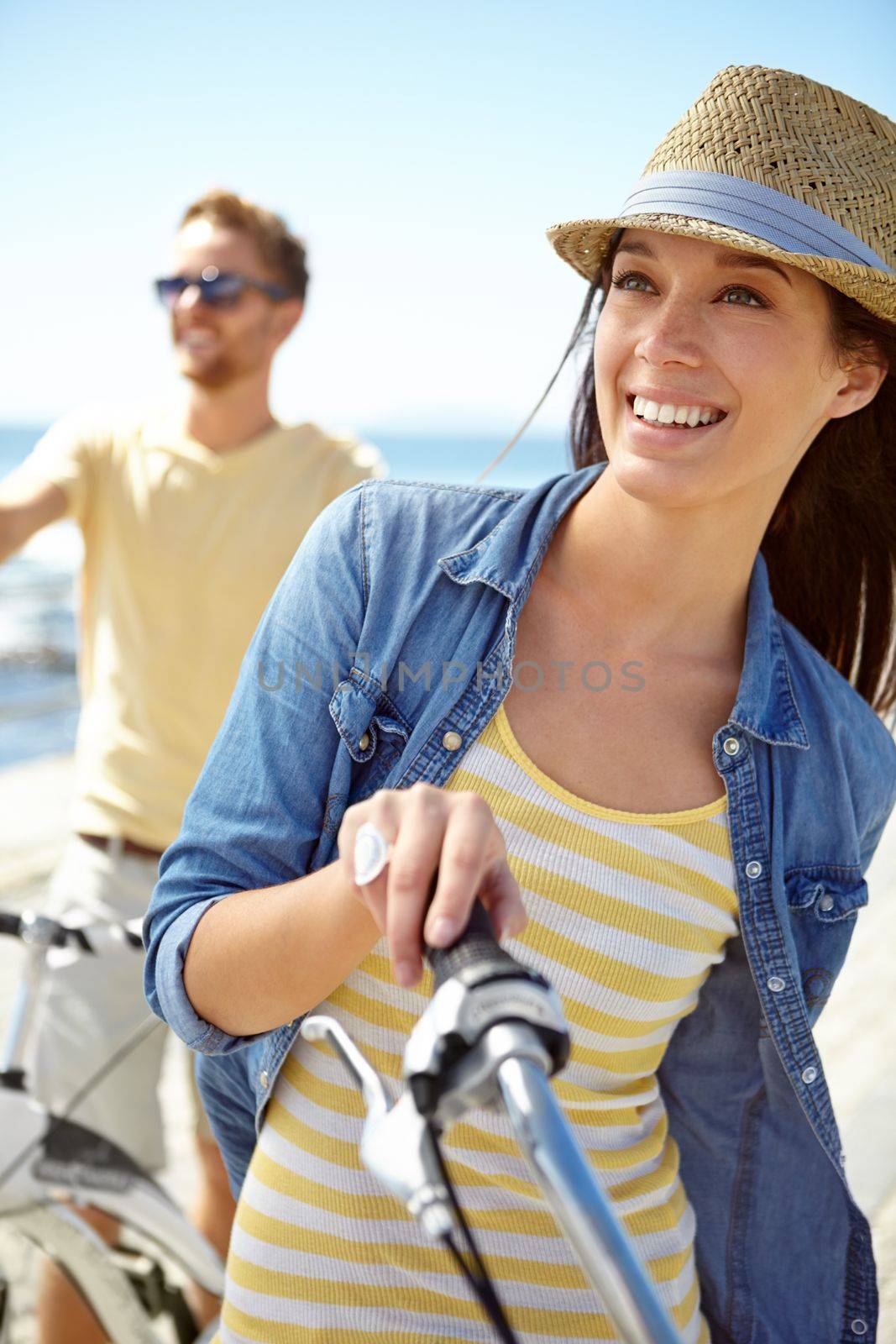 Bike, travel and couple with a woman on summer vacation or holiday riding on the promenade by the beach. Freedom, date and romance with a girlfriend outdoor for a ride on the coast during the day.
