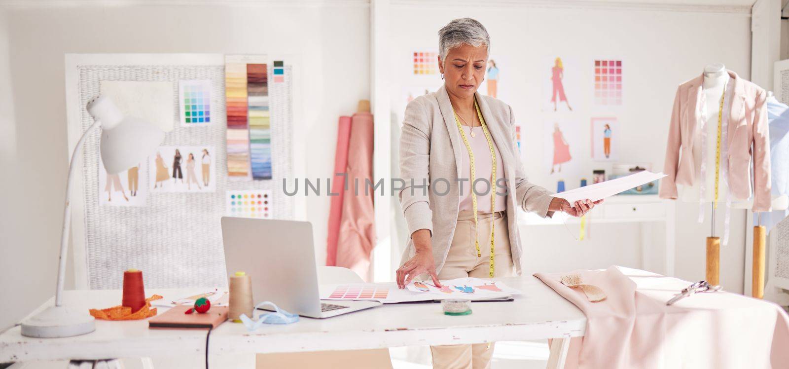 Planning, fashion and design with business woman in workshop studio for creative, tailor and review. Retail, boutique and shop with senior employee in clothing factory for fabric, graphic and textile.
