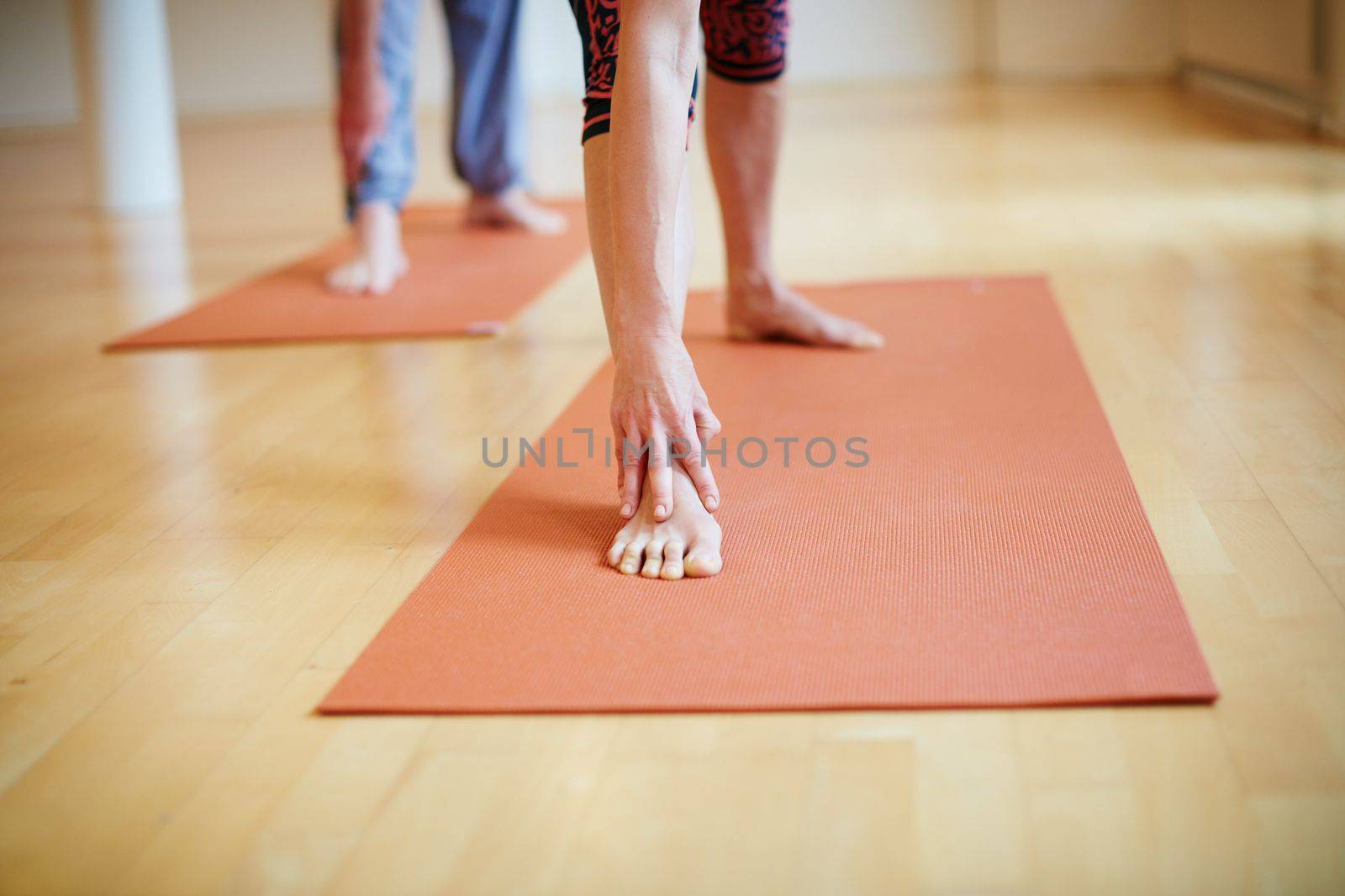 Yoga is part of their lifestyle. peoples legs as theyre doing yoga indoors