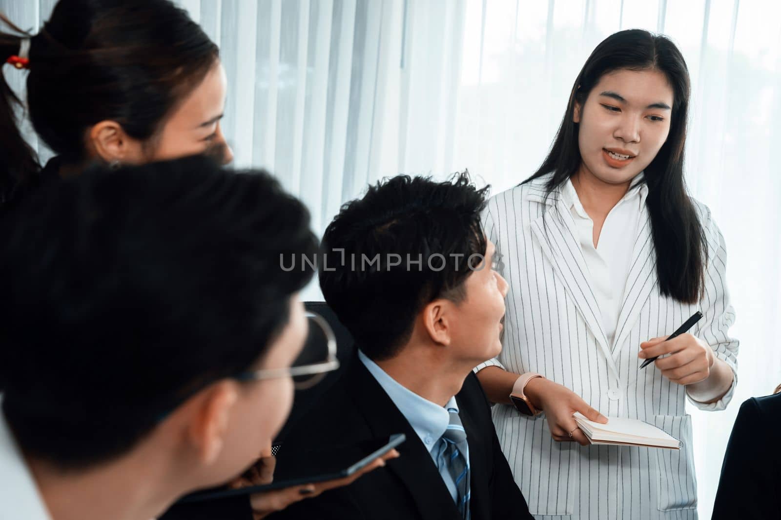 Harmony in office concept as business people analyzing dashboard paper together in workplace. Young colleagues give ideas at manager desk for discussion or strategy planning about project.