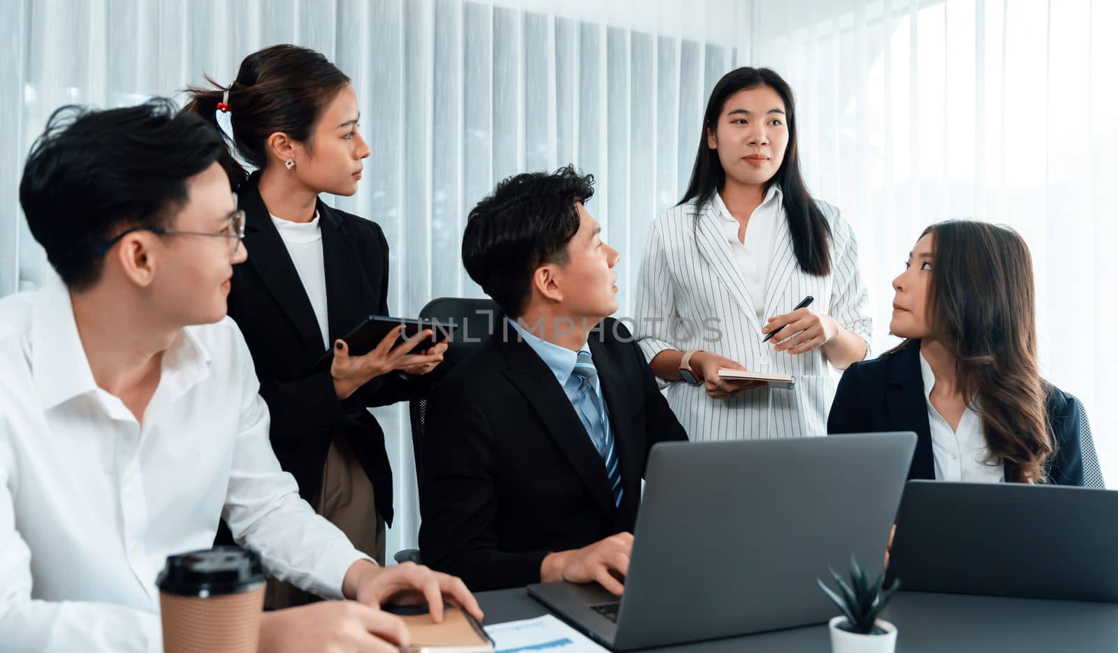 Harmony in office concept as business people analyzing dashboard paper together in workplace. Young colleagues give ideas at manager desk for discussion or strategy planning about project.