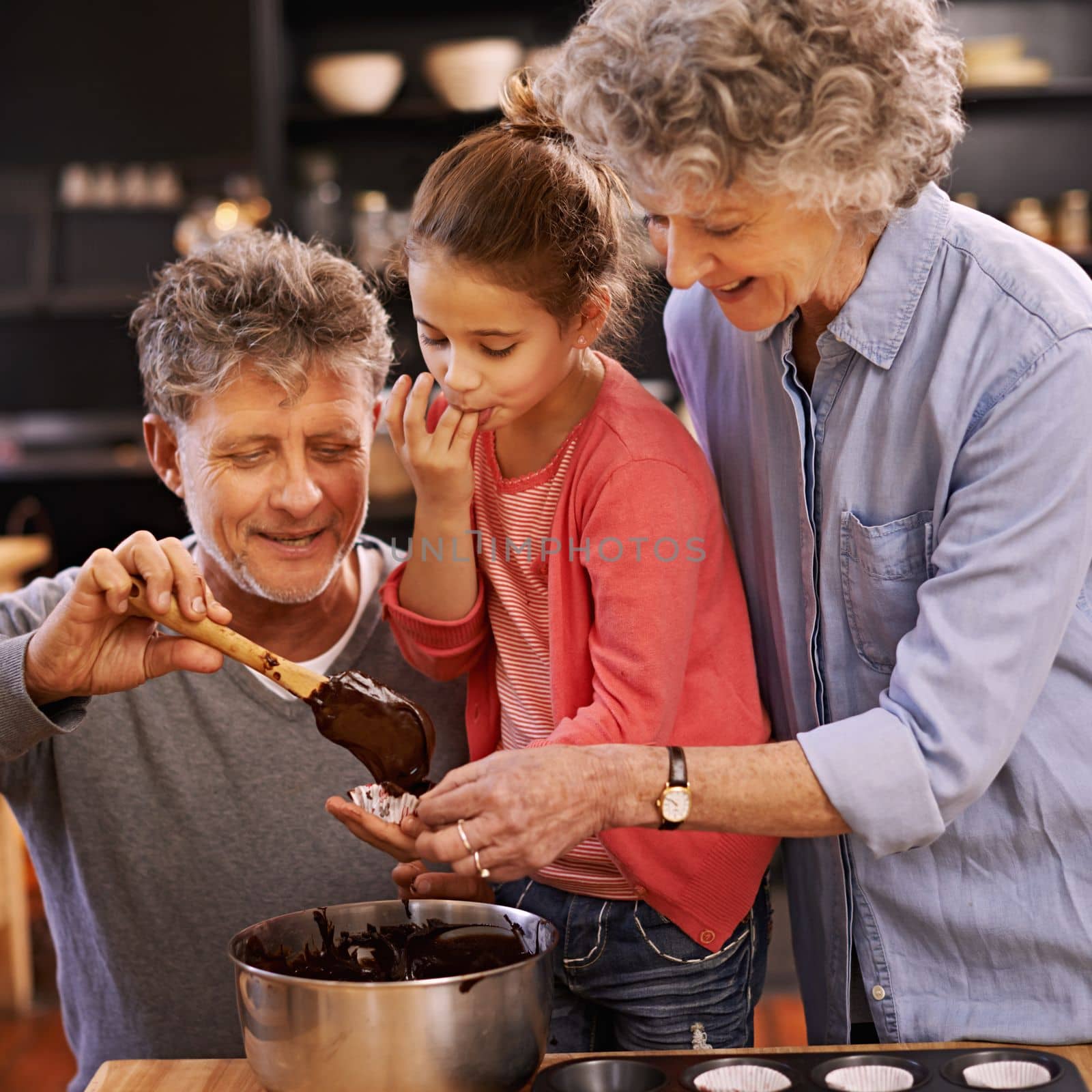 Wow, this is the best taste ever. A little girl cooking with her grandparents. by YuriArcurs