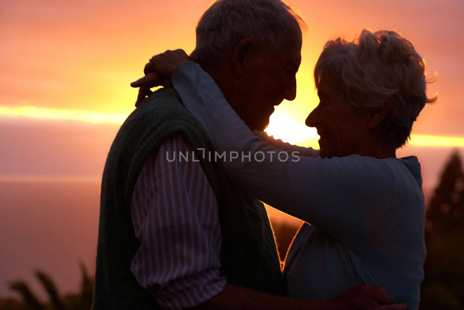 The romance is still going strong. an elderly couple sharing a romantic moment at sunset