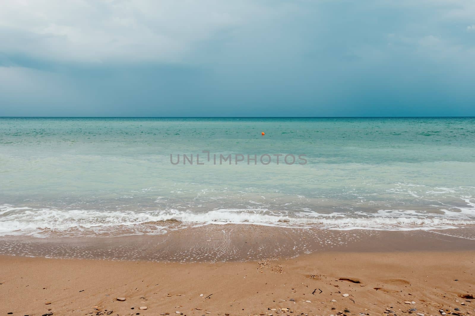 Golden sunset on the beach. Foamy waves rolling towards golden sand beach under low warm sun light. Slow motion. Nobody. Holiday recreation concept. Abstract nautical summer ocean sunset nature