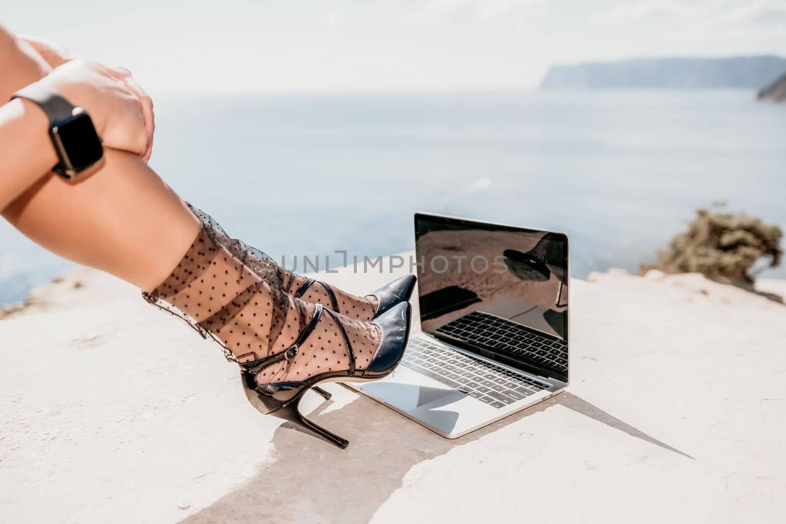 Happy girl doing yoga with laptop working at the beach. beautiful and calm business woman sitting with a laptop in a summer cafe in the lotus position meditating and relaxing. freelance girl remote work beach paradise