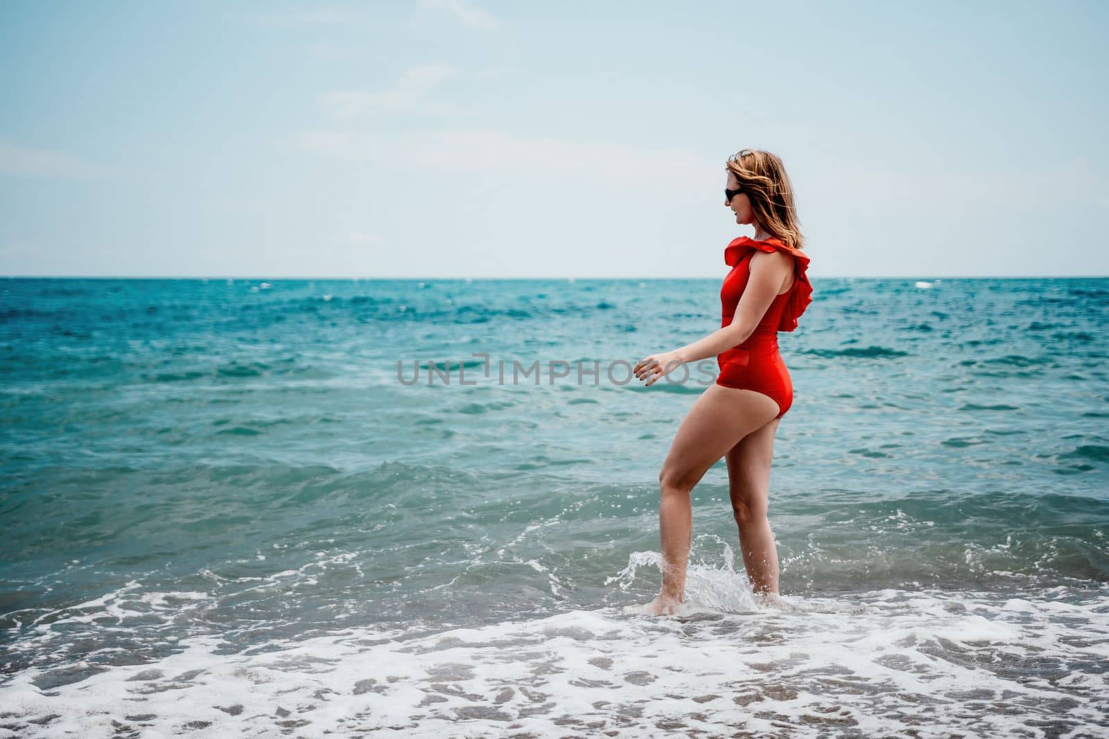 Young happy woman walks carefree on the seaside. Happy lady in red bikini. Portrait beautiful young woman relax smile around beach sea ocean in holiday vacation travel trip by panophotograph