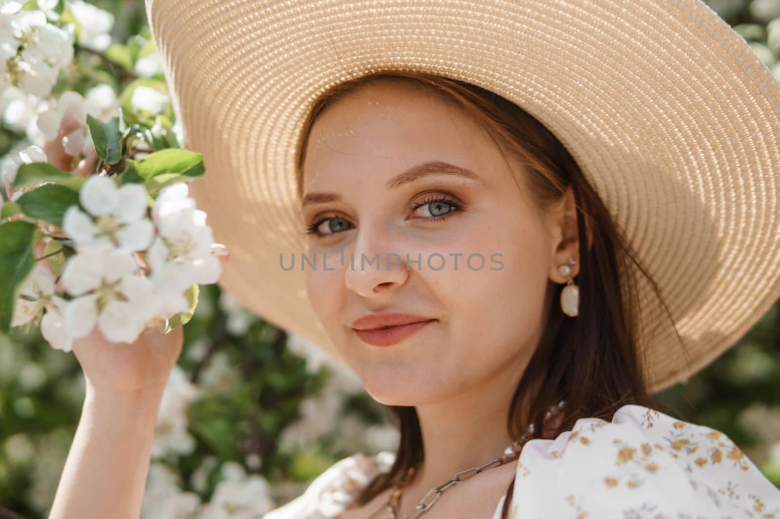 An attractive long-haired woman walks in the spring in the park of blooming apple trees. by Annu1tochka