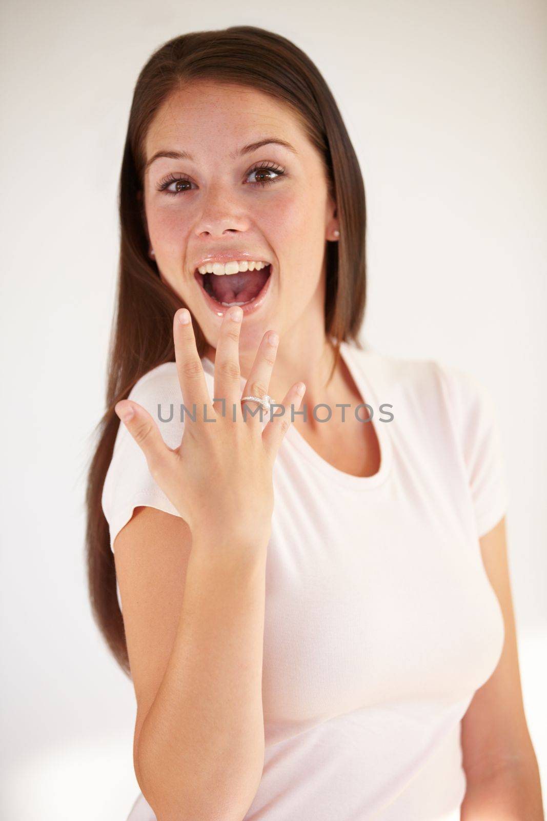 Portrait of woman excited with ring for engagement, marriage and wedding on white background. Love, wow and happy girl show diamond jewellery on hand for romance celebration, commitment and proposal by YuriArcurs