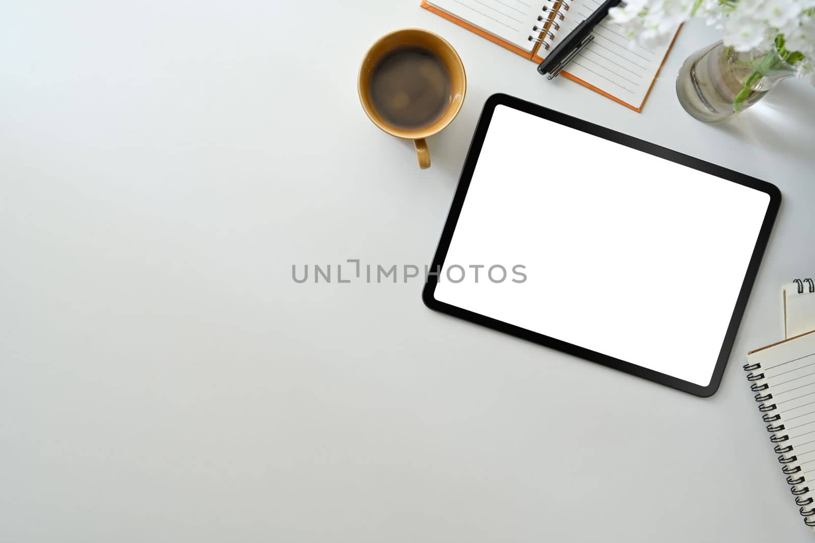Modern workplace wot digital tablet, cup of coffee and notepad on white table. Flat lay, Top view by prathanchorruangsak